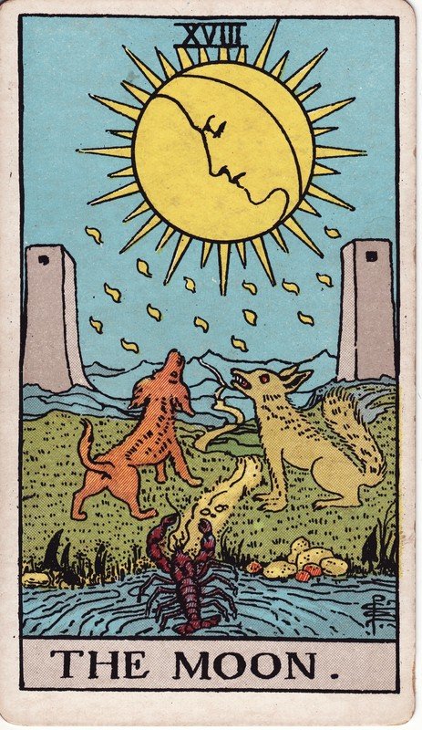 A carta A Lua no Rider–Waite–Smith: lua entre duas torres, um cão, um lobo e um lagostim saindo da água.